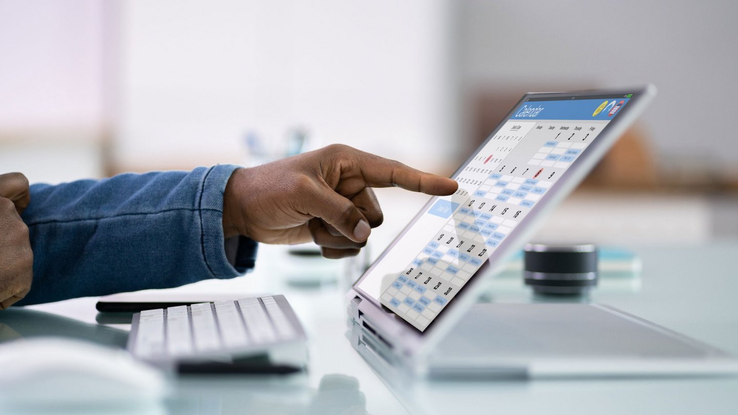 Hand interacting with a digital booking interface on a laptop during event planning.